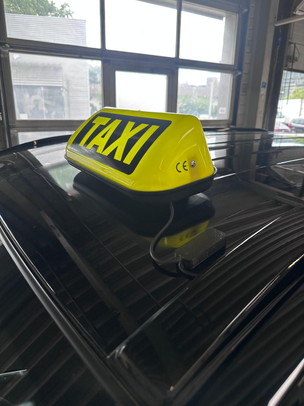 Gelbe Taxi-Dachleuchte mit flachem magnetischem Anschluss auf einem Fahrzeugdach