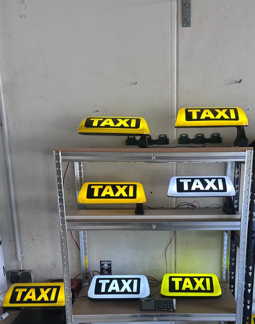 Regal mit gelben und weißen Taxi-Dachleuchten in verschiedenen Ausführungen