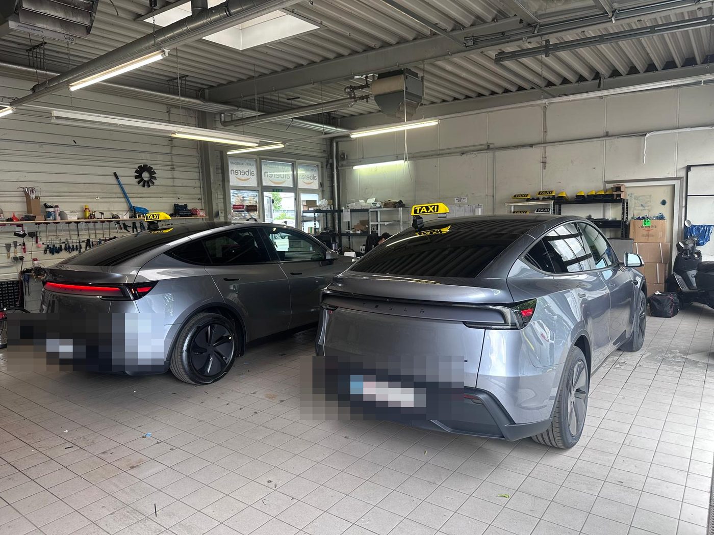 Zwei Tesla Model Y mit Taxi-Dachleuchten in der Einbauwerkstatt